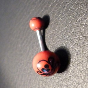 Piercing nombril rouge et noir motif : tête de mort